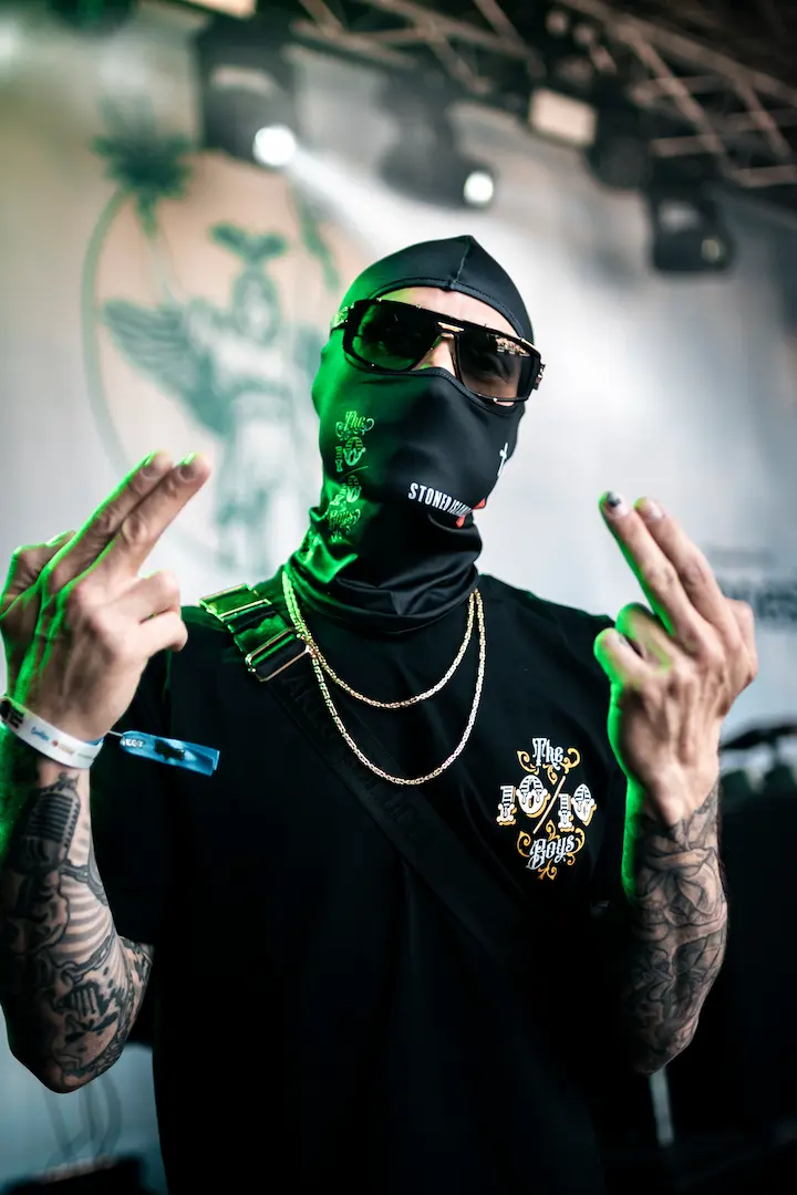 the 10/10boys events 2026 live event photo of a masked model wearing a black The 10/10 Boys tee under green stage lighting.