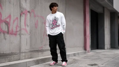 Pink streetwear outfit with a white Pink Long Sleeve Shirt, black cargos and clean sneakers on an urban street