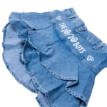 The 10/10 Boys denim skirt — detail of the waistband and 10/10 Boys branding