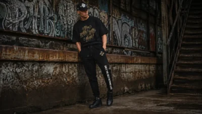 Man wearing black The 10/10 Boys joggers with side-leg branding, showing the full leg line and cuff