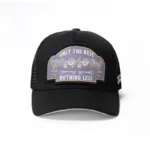 The 10/10 Boys Trucker Hat in black — front view with the "Only the Best, Nothing Less" badge patch