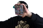 Mini Canvas No. 1 held up in one hand, showing its 10 × 10 cm size