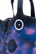 Close-up of the 10/10 Big Handbag: pink splatter over blue and the GavinBrownArts badge