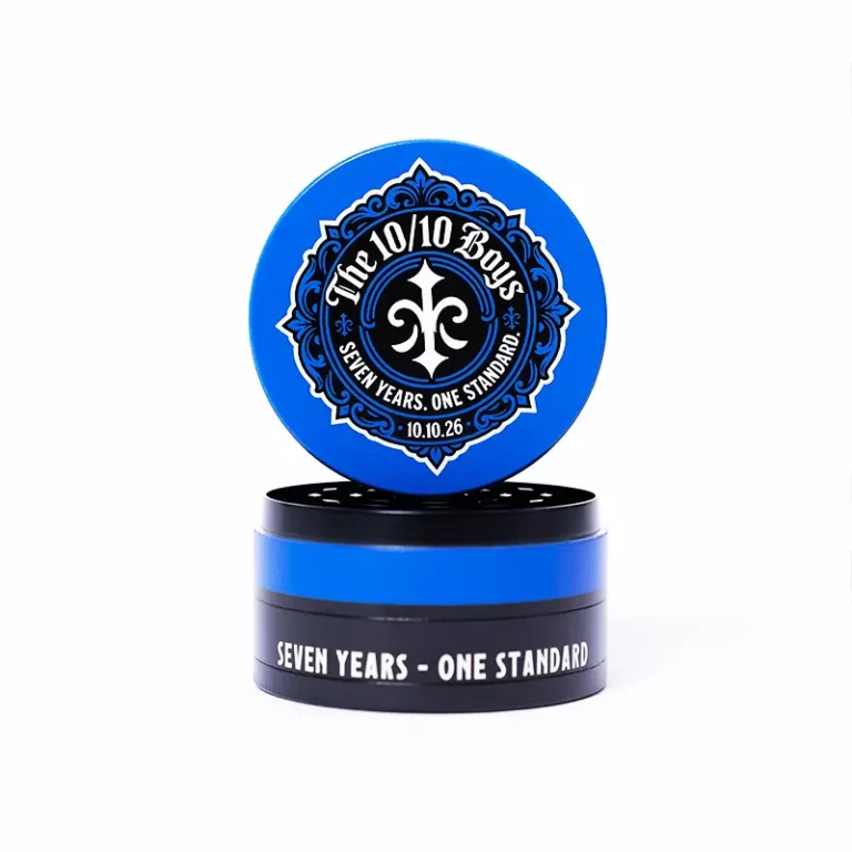 The 10/10 Boys 7th Anniversary Grinder — side view with the blue fleur-de-lis lid and SEVEN YEARS - ONE STANDARD around the base